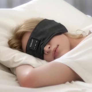 Person som sover på sidan med Rubicsons svarta pannband draget över ögonen och knapparna för uppspelning vid tinningen.