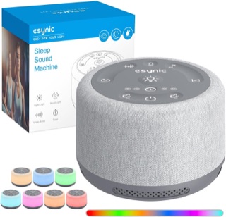 eSynic White Audio Machine, en rund grå ljudmaskin i tyg med knappar på ovansidan, visad bredvid sin förpackning och i sju olika ljusfärger.